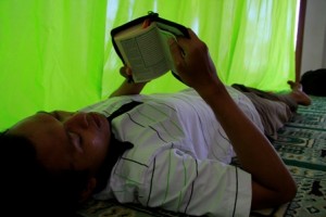 Ilustrasi orang yang membaca al quran sambil tidur